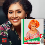 A black woman smiling with a political poster in the background