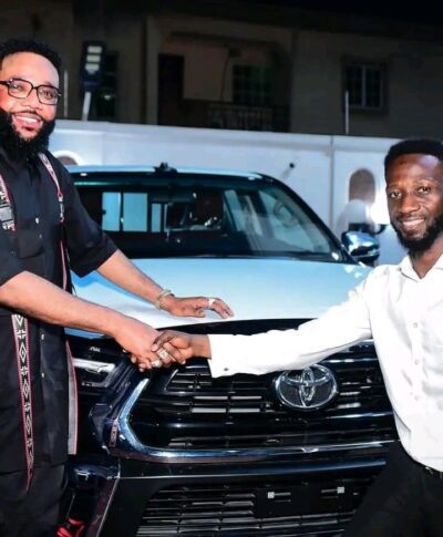 E-Money presenting car keys to one of his domestic staff 