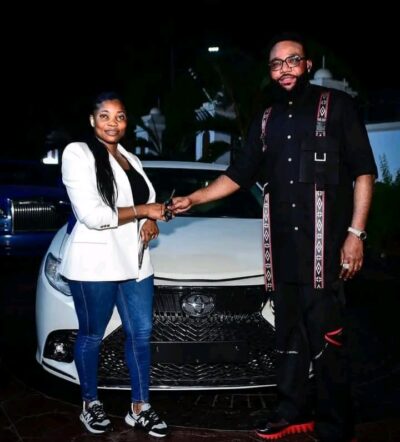 E-Money presenting car keys to one of his female staff 